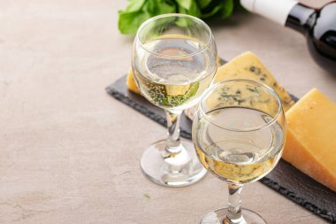 Gri masada farklı türde peynir ve şarap.