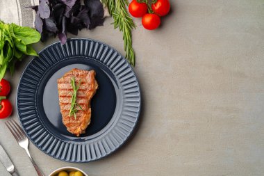 Mavi tabakta servis edilen ızgara biftek.