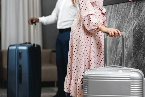 Onherkenbare man en vrouw met koffers bij de receptie in hotel — Stockfoto