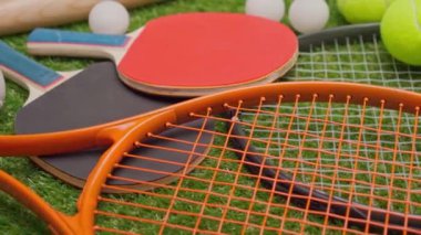 Spor malzemeleri, raketler ve çim arka planda toplar 