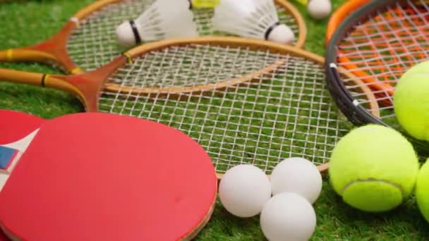 Sportutrustning, racketar och bollar på gräs bakgrund — Stockvideo