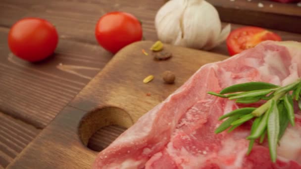 Čerstvé steaky ze syrového masa na dřevěné desce s kořením zblízka — Stock video
