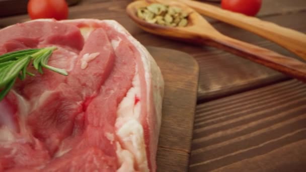 Bistecche fresche di carne cruda su tavola di legno con spezie da vicino — Video Stock