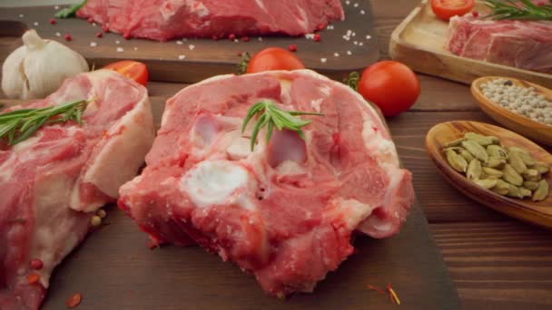 Bistecche fresche di carne cruda su tavola di legno con spezie da vicino — Video Stock