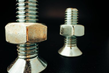 Siyah arka planda metal vidalar ve fındıklar