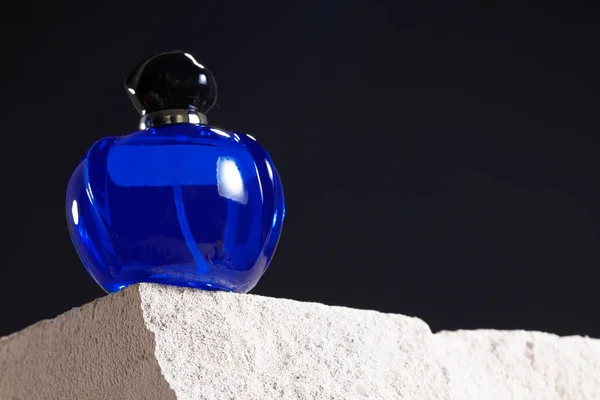 Bottle of perfume on cinder block close up — Stock Photo, Image