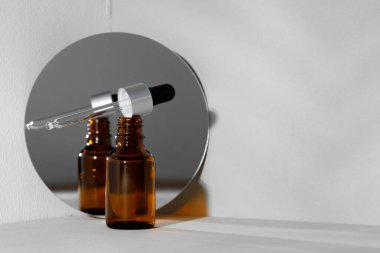 Cam kavanoz kozmetik yağı ve aynalı yaratıcı fotoğraf