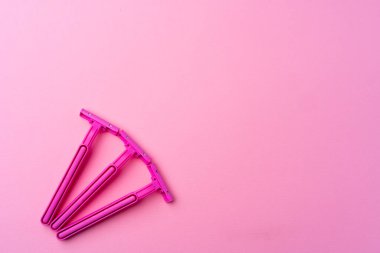 Pembe arka plan görünümünde tek kullanımlık kadın jiletleri
