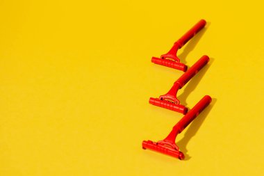 Sarı arka planda tek kullanımlık jiletler, stüdyo çekimi.