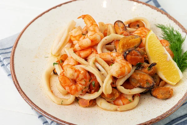 Stir fried seafood with sauce on plate with napkin — Stock Photo, Image