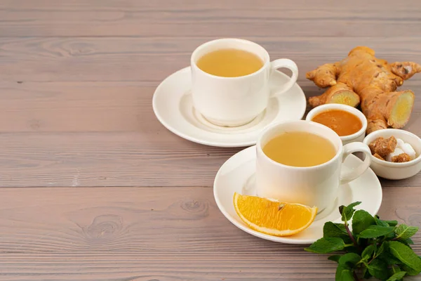 Filiżanka herbaty z imbirem i miętą na drewnianym stole — Zdjęcie stockowe
