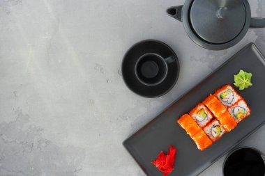 Kaliforniya suşi rulosu gri arka planda servis edilir