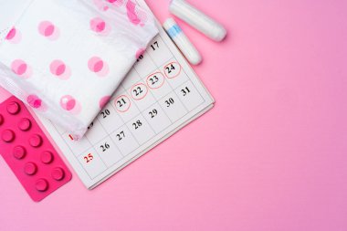 Bayan adet öncesi hijyenik eşyalarla takvim sayfası
