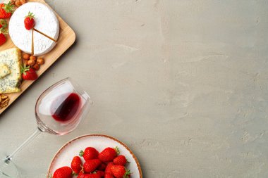 Peynir ve meyve kompozisyonu gri masada.