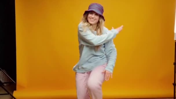 Joven mujer feliz en panama sombrero bailando sobre fondo amarillo — Vídeos de Stock