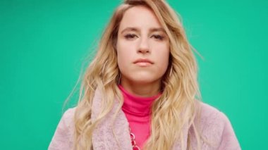 Pembe elbiseli zarif genç bir kadın, darphane arka planına karşı ritim tutuyor.