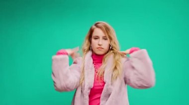 Pembe elbiseli zarif genç bir kadın, darphane arka planına karşı ritim tutuyor.