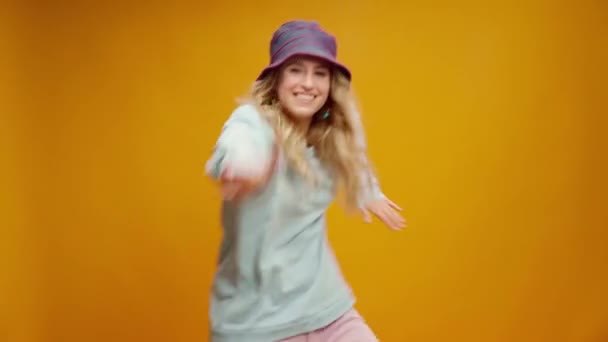 在黄色背景下跳舞的年轻而快乐的女人 — 图库视频影像