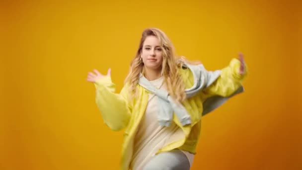 Vrouw professionele danser dansen in studio tegen gele achtergrond — Stockvideo