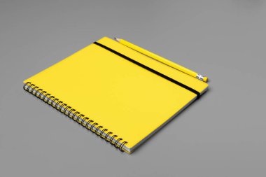 Gri arka planda sarı kalemli sarı not defteri