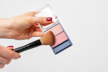 Beyaz arkaplana karşı kadın el ele makyaj paleti