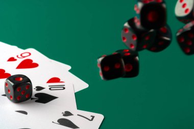 Zarlar ve kartlar masaya saçılmış.