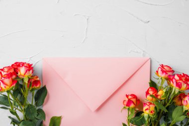 Üzerinde çiçekler olan pembe bir zarf. Romantik mektup