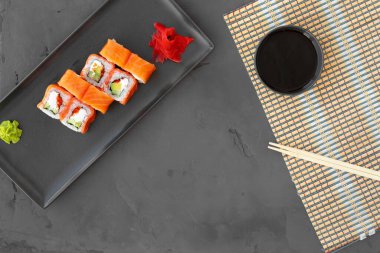 Philadelphia suşi rulosu siyah arka planda üst görünümde