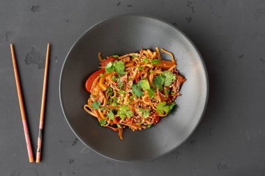 Sebzeli rafadan şehriye ve gri arka planda et.