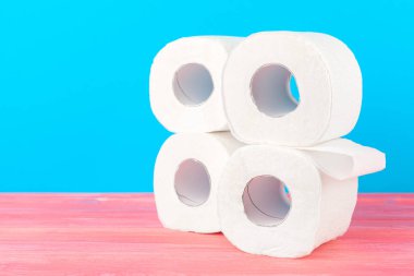 Parlak mavi arkaplanda tuvalet kağıdı yığını