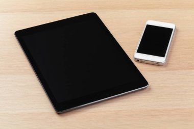 dijital tablet ve akıllı telefon masada.