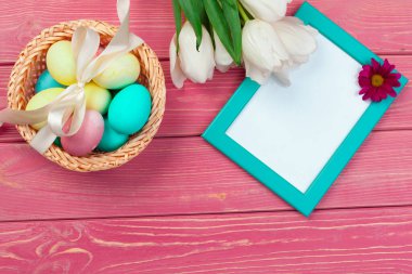 Paskalya, bayram, gelenek ve nesne konsepti - renkli yumurta ve lale çiçeklerinin ahşap arka planda kapatılması