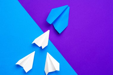 Beyaz kağıt uçak mavi ve mor kağıt arka planda