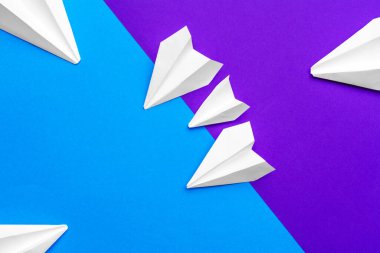 Beyaz kağıt uçak mavi ve mor arka planda