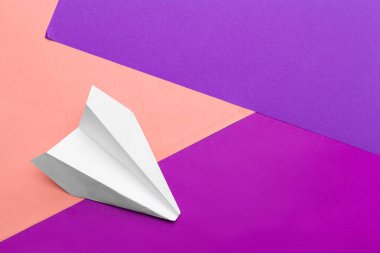 Renkli blok kağıt arka planında beyaz kağıt uçak