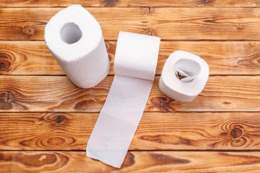 Tuvalet kağıdı ahşap arka plan görünümünde yuvarlanıyor.