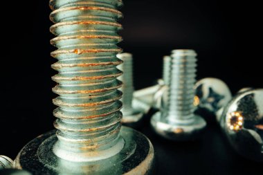 Siyah arka planda metal vidalar ve fındıklar