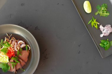 Asya çorbası, domuz eti ve erişteli Ramen, gri arka planda.