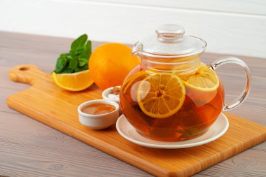 Siyah çay ve narenciye parçalı cam çaydanlık.