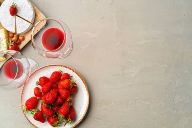 Peynir ve meyve kompozisyonu gri masada.