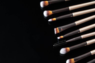 Siyah arkaplanda makyaj fırçası koleksiyonu