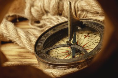 Ahşap zemin üzerinde gemi halatı ve pusula