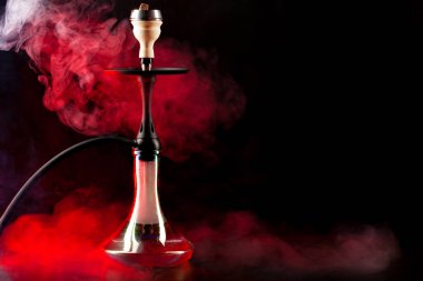 Siyah arkaplanda renkli sis ile nargile içmek