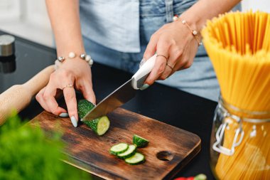 Tahtada salatalık kesen tanınmayan bir kadın. Yakından.