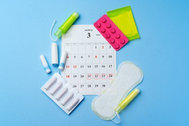 Bayan adet öncesi hijyenik eşyalarla takvim sayfası