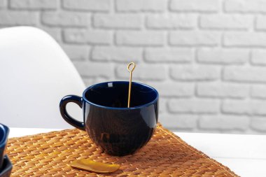 Klasik mavi boş seramik çay fincanı mutfak masasında.