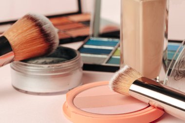 Pembe arka planda dekoratif kozmetik ürünler. Kapat.