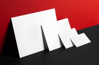 Kırmızı ve siyah arkaplanda boş beyaz kartvizitler