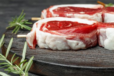 Koyu arkaplanda yemek pişirmek için malzemeli taze et.