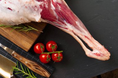 Tahtada kızarmaya hazır taze çiğ kuzu bacağı.